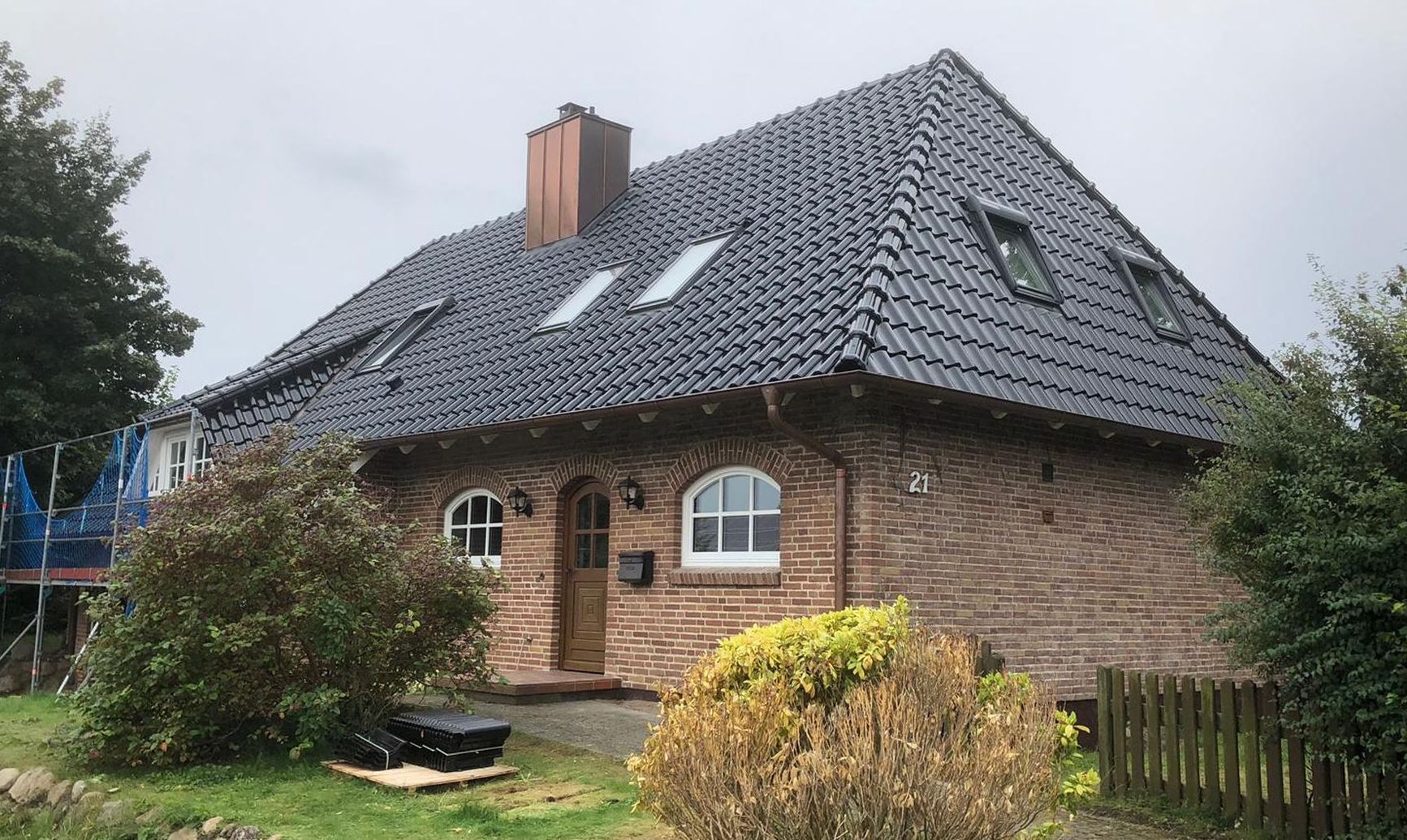 Energetische Dachsanierung mit Tondachziegeln, Kupferdachrinne, Schornsteinverkleidung sowie Veluxfenstern in Süderbrarup.